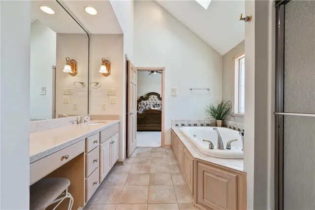 a large bathroom with a tub sink and mirror