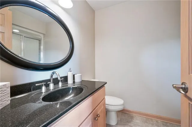a bathroom with a granite countertop double vanity and a mirror
