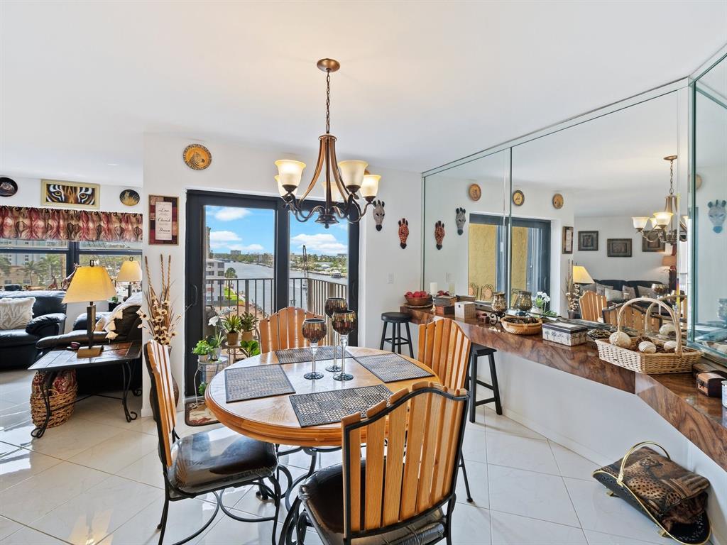501 North Riverside Drive, Unit 601 Pompano Beach, FL 33062 - Photo 19 of 32 a view of a dining room and livingroom with furniture wooden floor a chandelier