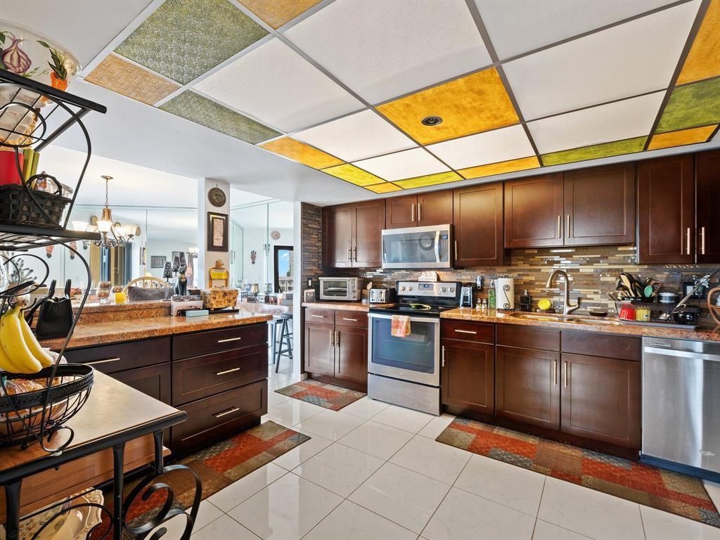 501 North Riverside Drive, Unit 601 Pompano Beach, FL 33062 - Photo 4 of 32 a kitchen with stainless steel appliances kitchen island granite countertop a refrigerator and stove