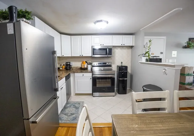 a kitchen with stainless steel appliances a stove a refrigerator and cabinets