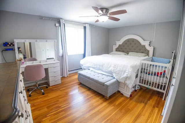 a bedroom with a bed and wooden floor