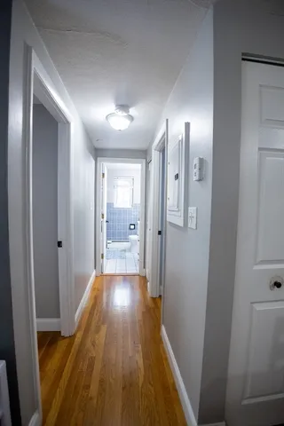 a view of a hallway with wooden floor