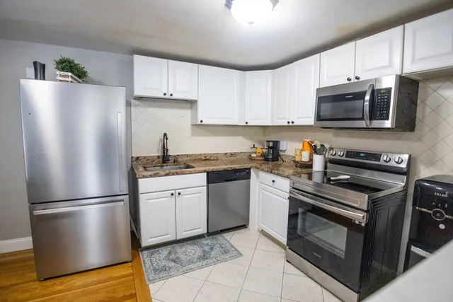 a kitchen with stainless steel appliances granite countertop a refrigerator sink and microwave