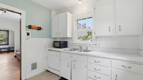 a kitchen with white cabinets and white appliances