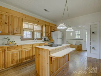 a kitchen with stainless steel appliances granite countertop a sink a stove and a wooden floors