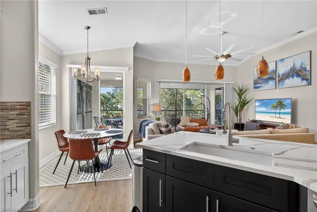 a view of a dining room and livingroom with furniture wooden floor a chandelier
