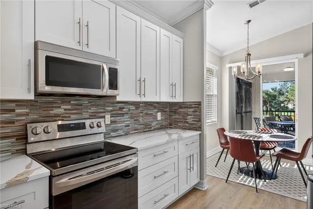 a kitchen with appliances a sink cabinets and wooden floor