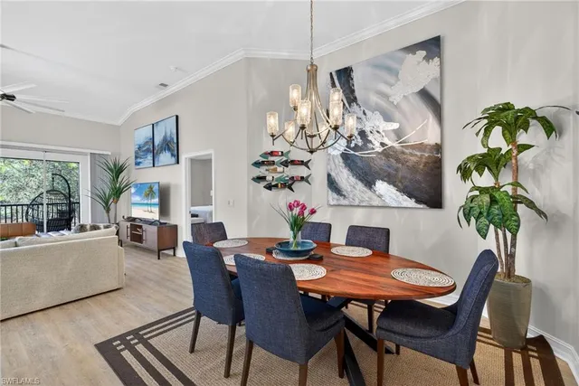a view of a dining room with furniture a livingroom and chandelier