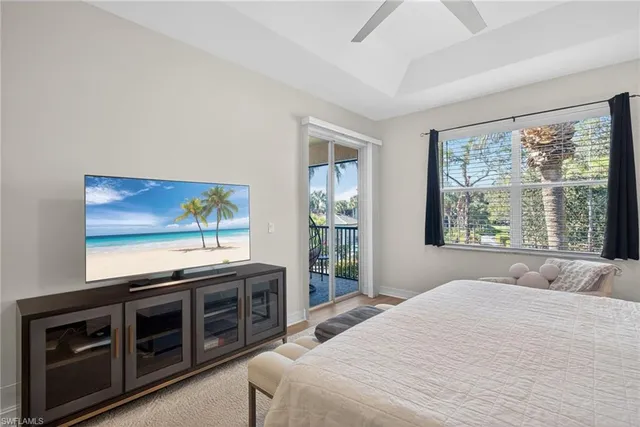 a bedroom with a bed and a flat tv screen on dresser
