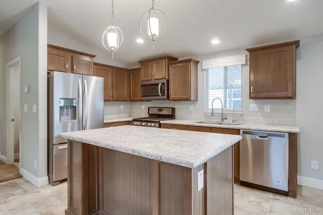 a kitchen with stainless steel appliances granite countertop a refrigerator stove microwave and sink