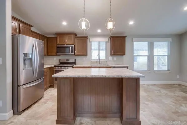 a kitchen with kitchen island a sink stainless steel appliances and window
