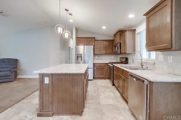 a kitchen with kitchen island a sink stainless steel appliances and cabinets
