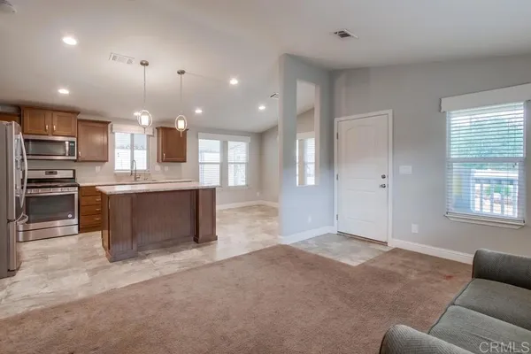 a view of kitchen with kitchen island and stainless steel appliances