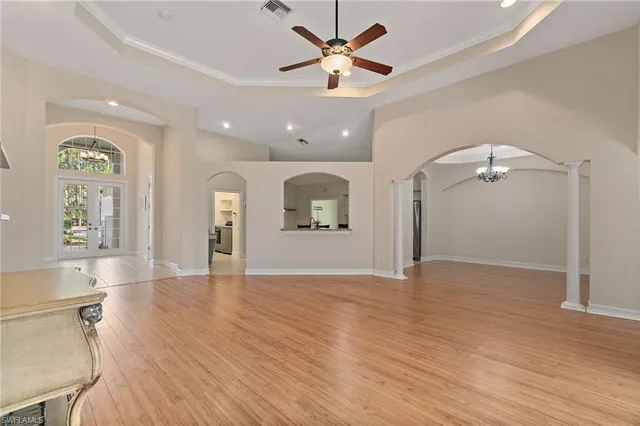 a view of an empty room with window and wooden floor