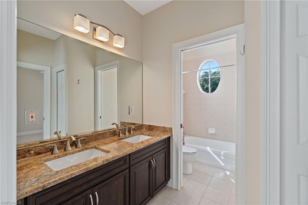 1158 Oakes Boulevard Naples, FL 34119 - Photo 22 of 40 Bathroom featuring double vanity, light tile patterned floors, and shower / tub combination