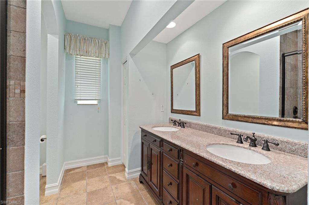 1158 Oakes Boulevard Naples, FL 34119 - Photo 33 of 40 Full bathroom with double vanity and baseboards
