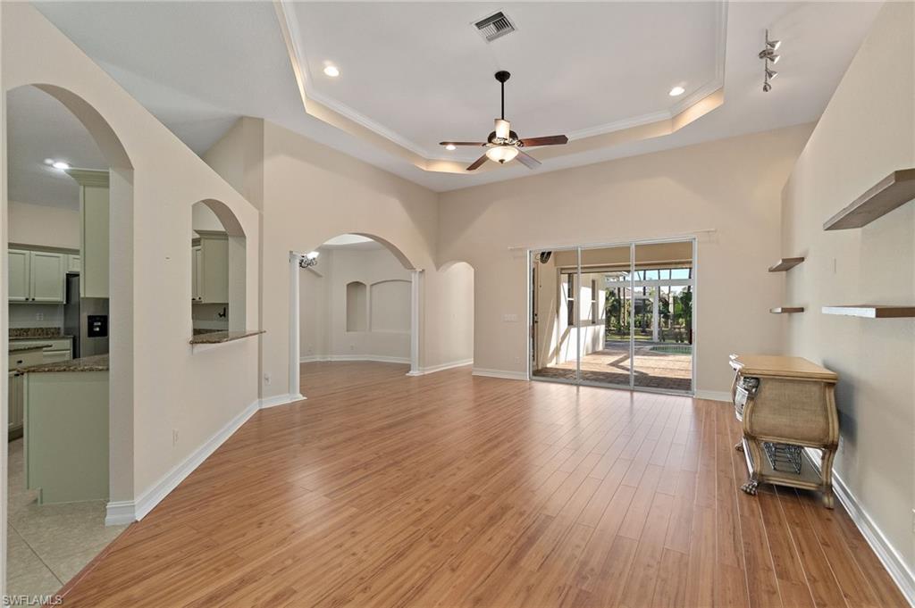 1158 Oakes Boulevard Naples, FL 34119 - Photo 10 of 40 Unfurnished living room with arched walkways, light wood-style floors, a ceiling fan, ornamental molding, and recessed lighting