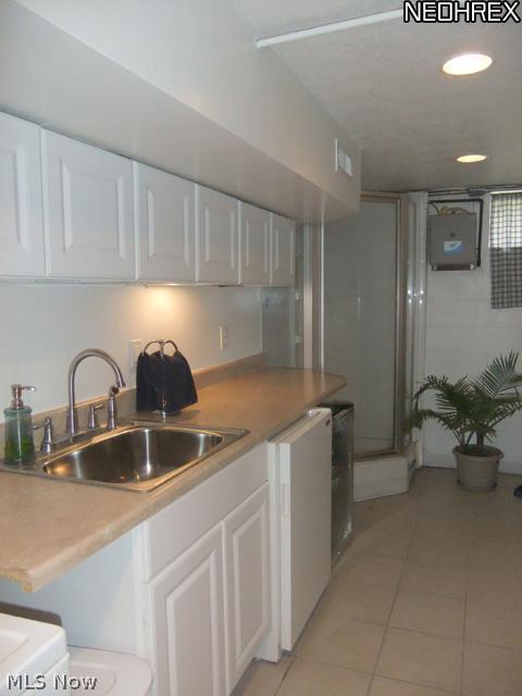 6468 South Cleveland Massillon Road Clinton, OH 44216 - Photo 18 of 25 The laundry room/2nd full bathroom of the home is located off of the family room. This space shows off tile floors, white cabinets and a corner shower.