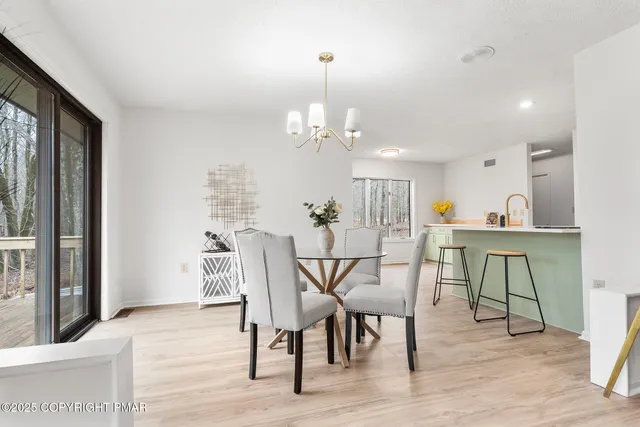 a dining room with furniture a chandelier and wooden floor