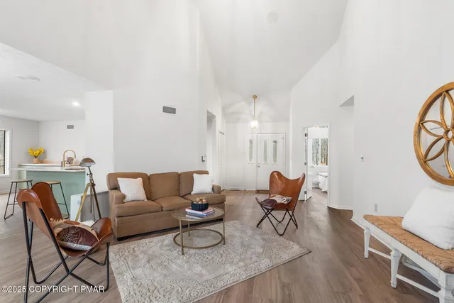 a living room with furniture a clock on wall and a table