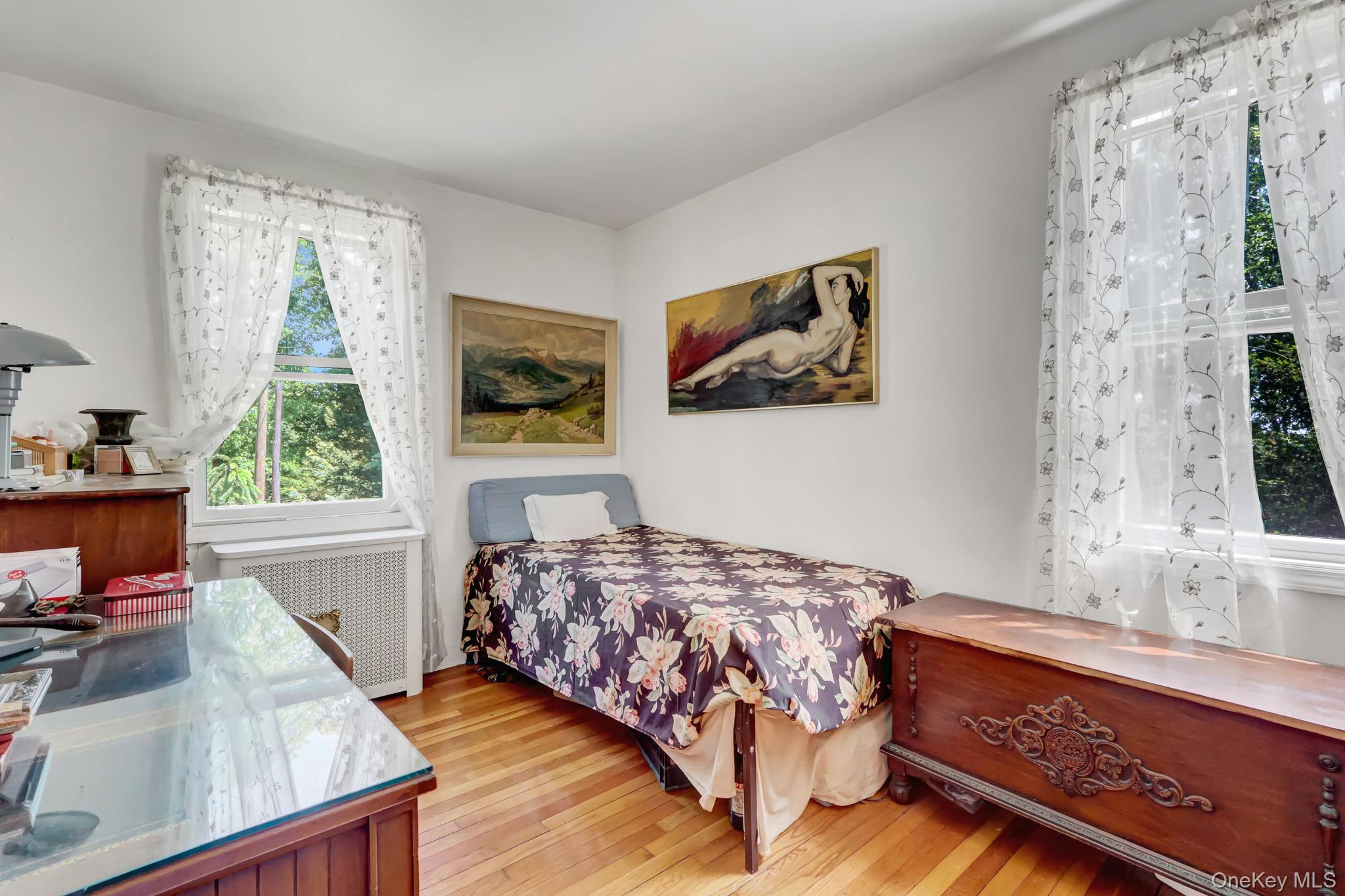 100 Elwood Road Northport, NY 11768 - Photo 20 of 39 Bright room featuring hardwood flooring and multiple windows with white trim