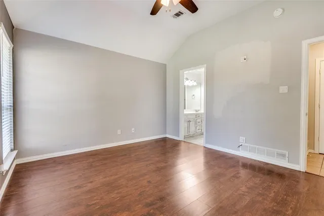 an empty room with wooden floor and window