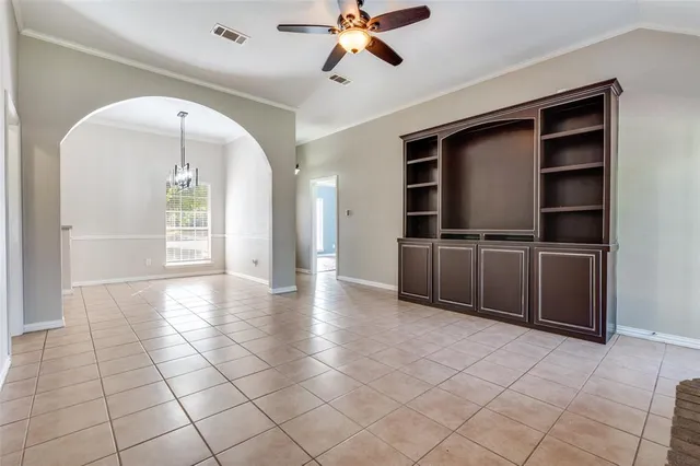 a view of a livingroom with a chandelier fan and windows