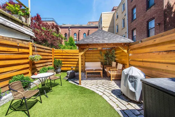 a view of a patio with table and chairs with wooden floor and fence