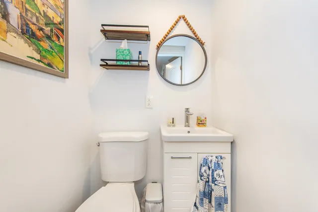 a bathroom with a toilet a sink and a mirror