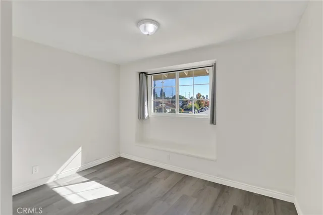 an empty room with wooden floor and window