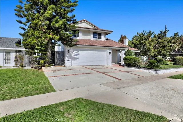 a front view of a house with a yard and potted plants