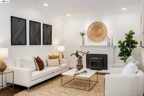 a living room with furniture a fireplace and a potted plant
