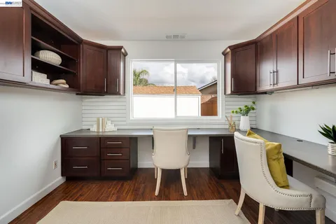 a kitchen with stainless steel appliances a table chairs in it and wooden floors