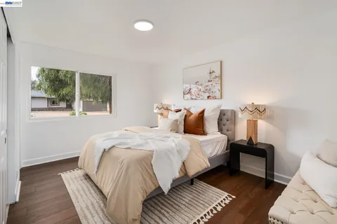 a large bed sitting in a bedroom next to a window