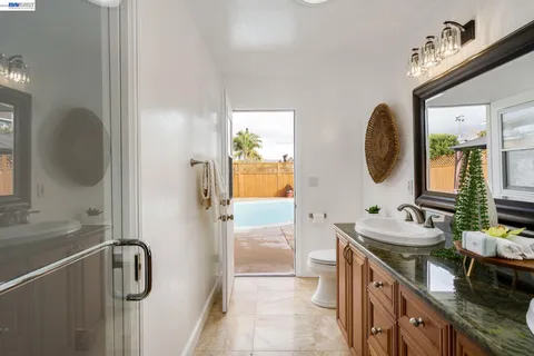 a en suite bathroom with a granite countertop sink and a mirror