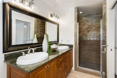 a bathroom with a granite countertop sink and a mirror