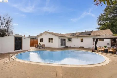 a view of a house with a swimming pool and a chairs