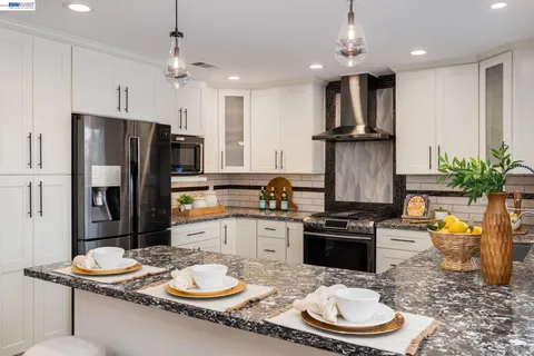 a kitchen with granite countertop a sink appliances and cabinets