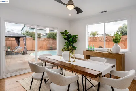 a dining room with furniture a chandelier and wooden floor