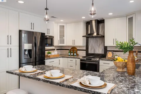 a kitchen with granite countertop a sink appliances and cabinets
