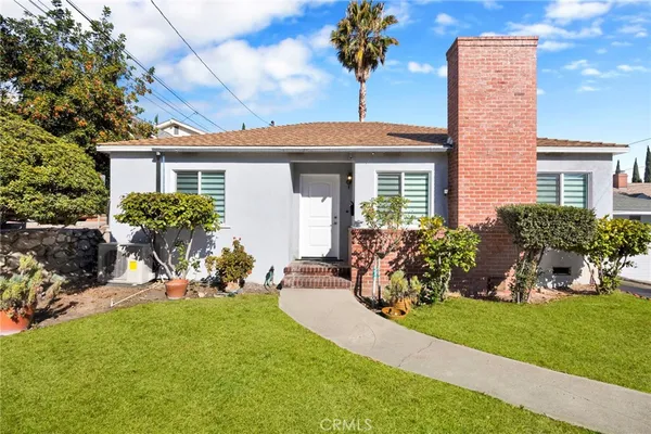 a front view of a house with a garden