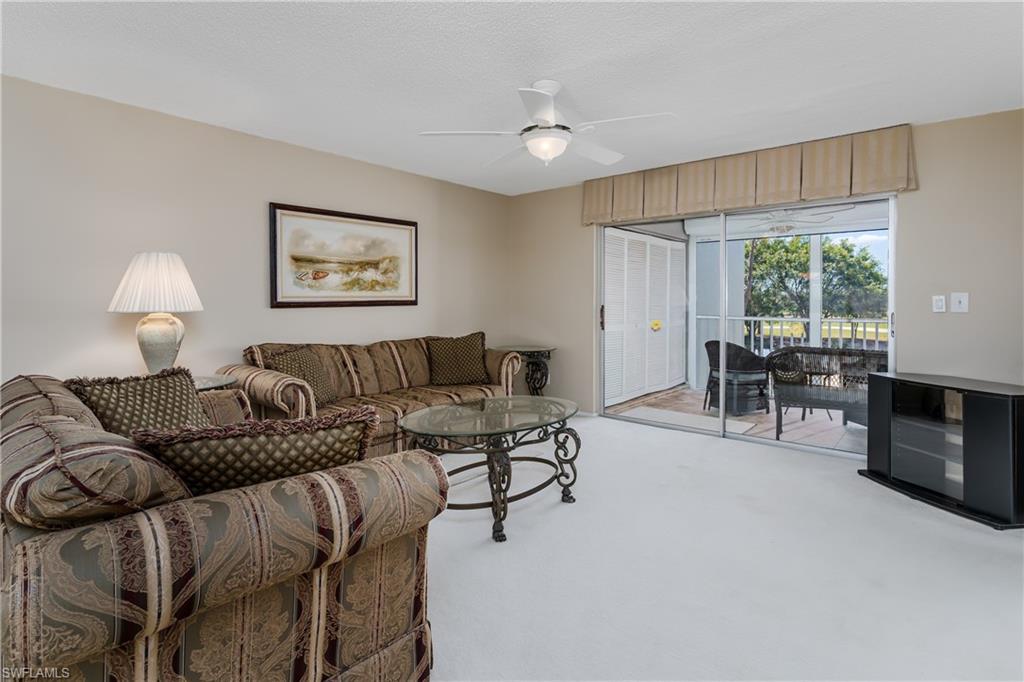5515 Rattlesnake Hammock Road, Unit 205 Naples, FL 34113 - Photo 11 of 46 a living room with furniture and a flat screen tv