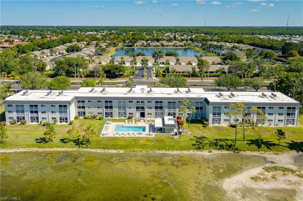5515 Rattlesnake Hammock Road, Unit 205 Naples, FL 34113 - Photo 30 of 46 a view of a swimming pool with a lawn chairs and plants