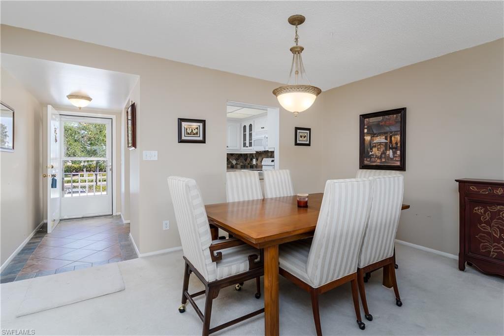 5515 Rattlesnake Hammock Road, Unit 205 Naples, FL 34113 - Photo 8 of 46 a view of a dining room with furniture window and wooden floor