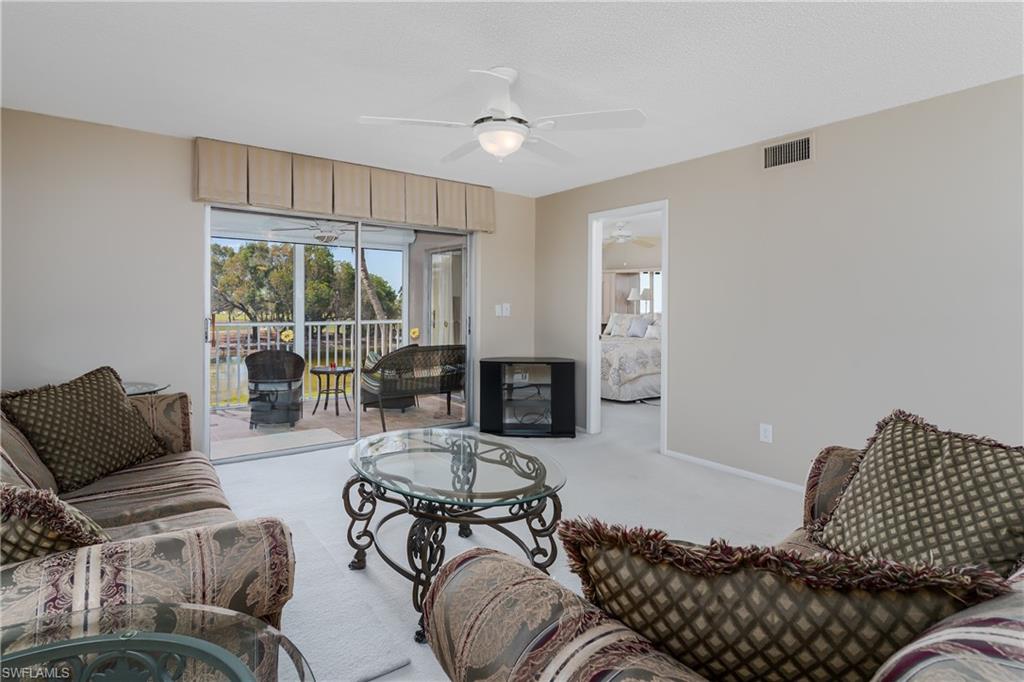 5515 Rattlesnake Hammock Road, Unit 205 Naples, FL 34113 - Photo 10 of 46 a living room with furniture window and a flat screen tv