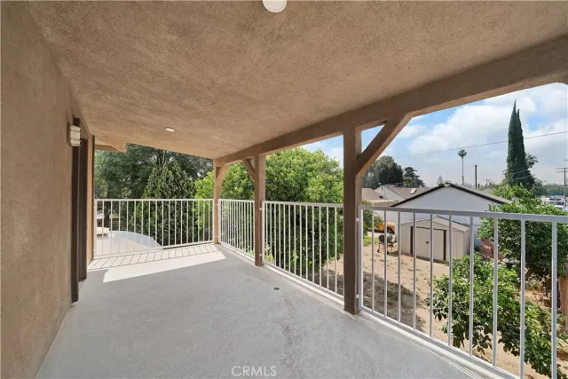 a view of a deck with a large window and wooden fence