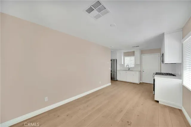 a view of a kitchen with a sink stove cabinets and empty room