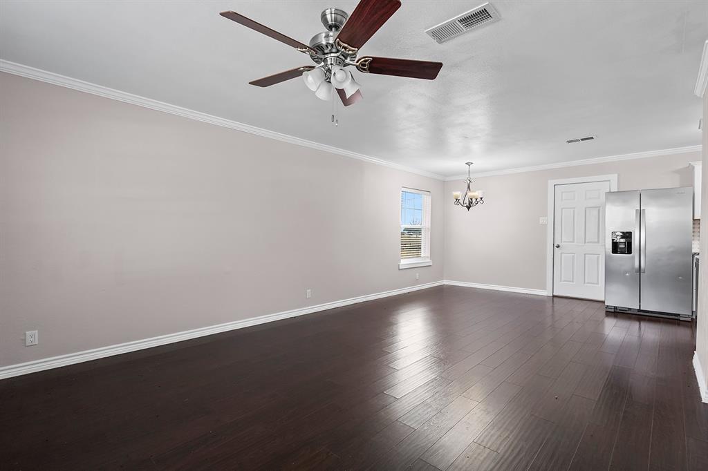 1135 Reed Circle Howe, TX 75459 - Photo 7 of 28 an empty room with wooden floor chandelier fan and windows