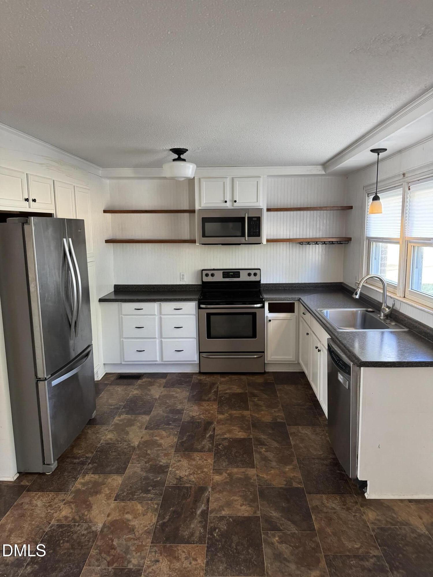 15008 Creedmoor Road Wake Forest, NC 27587 - Photo 3 of 14 a kitchen with stainless steel appliances granite countertop a refrigerator a stove a sink and a microwave